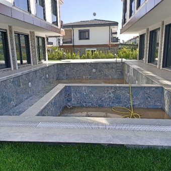 Ayvalık Güzelbahçe Evlerinde Satılık Lüks Deniz Manzaralı 1+1 Sıfır Daire.